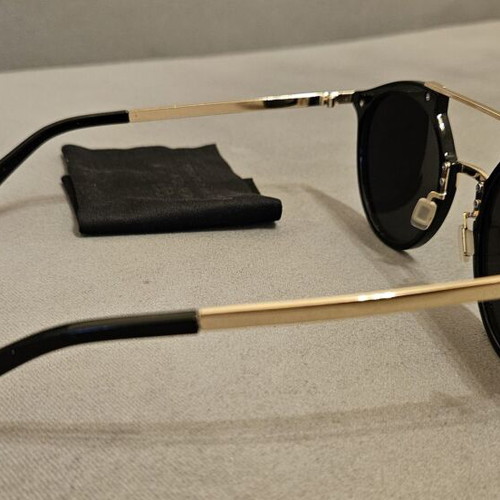Modern sunglasses with gold frame and black round lenses