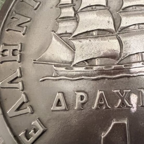 Decorative embossed drachma coin