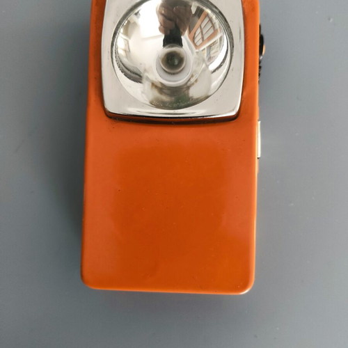 Vintage orange flat pocket flashlight used with retro UCAR battery