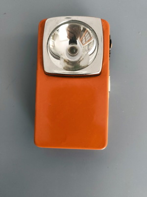 Vintage orange flat pocket flashlight used with retro UCAR battery