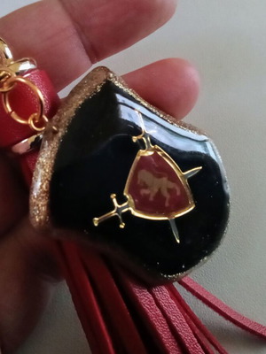 Handmade pendant or keychain with medieval symbols and red tassel