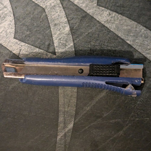 Blue utility knife used with broken back edge