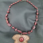 Necklace like new with red beads and metal leaf pendant