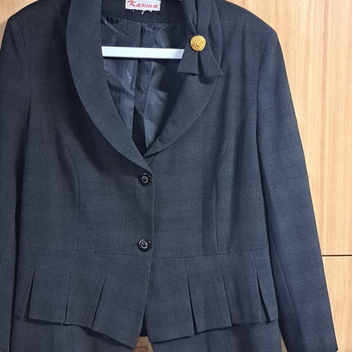 Women's black jacket with unique collar design and metallic detail