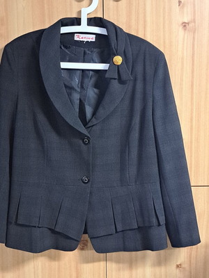 Women's black jacket with unique collar design and metallic detail
