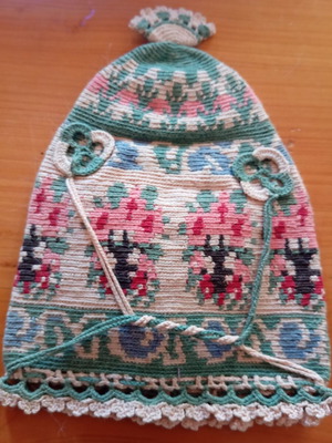 Handmade traditional embroidered or knitted pouch hat with folk motifs