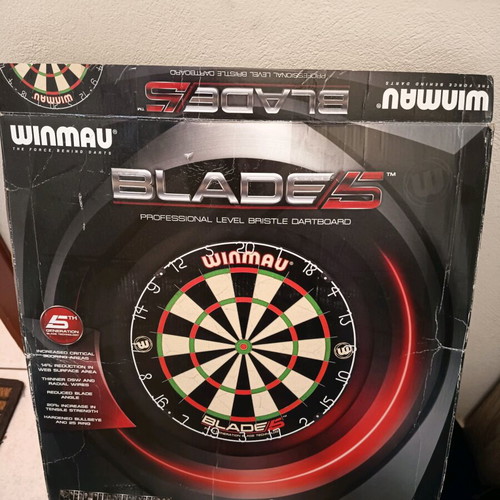 Winmau Blade 5 dartboard used with darts and wooden backing