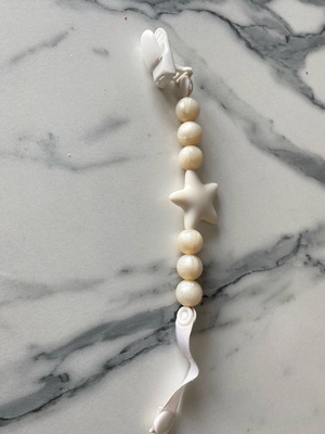 Nibbling pacifier clip used with white pearl-like beads