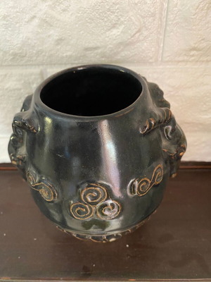 Black ceramic vase with ram’s head decoration