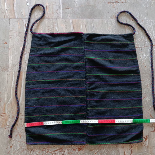 Traditional black apron with horizontal stripes used