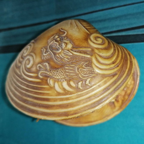 Vintage carved shell with dragon and scenic details