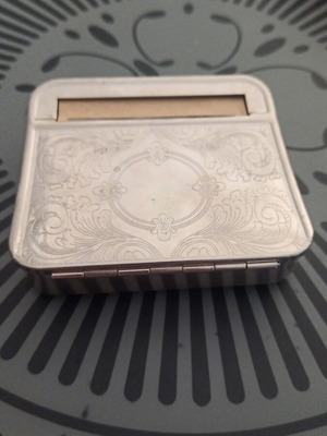 Metal tobacco case used for storing and rolling cigarettes