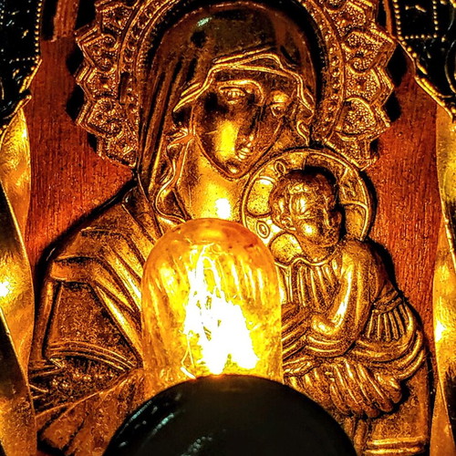 Vintage illuminated icon of Virgin Mary and Christ Child with lamp