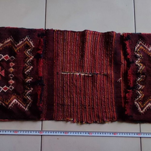 Old woven double horse saddle bag used with fabric tears