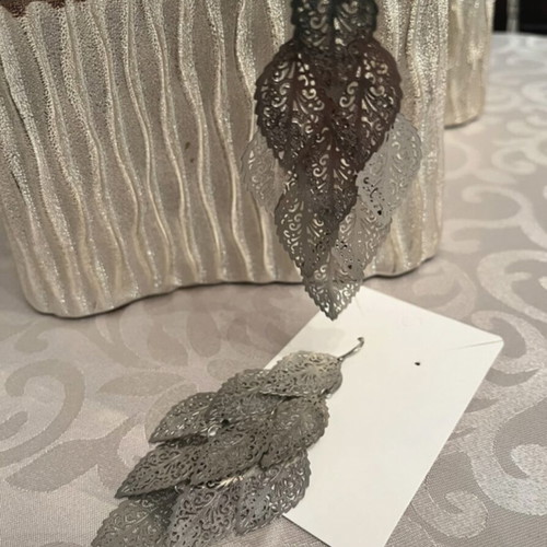 Silver dangling earrings with leaf design used