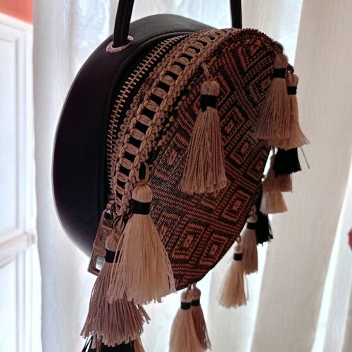 Round crossbody bag black like new, with tassels
