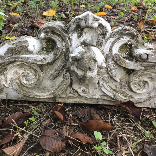 Old plaster pediment used with spiral motifs and human head