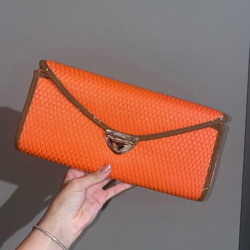 Orange hand clutch bag used with light wear