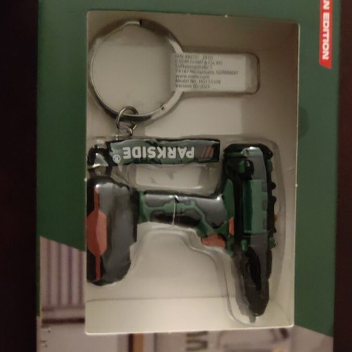 Set of various keychains with gun, drill and ribbon, unused