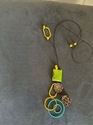 Necklace with a cord decorated with colorful motifs and metal rings. purchased from an island