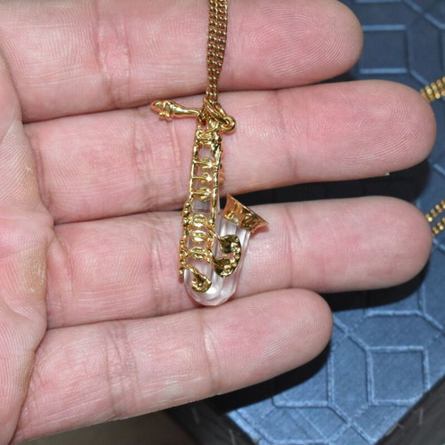 Swarovski necklace with saxophone pendant and crystal like new, gold plated
