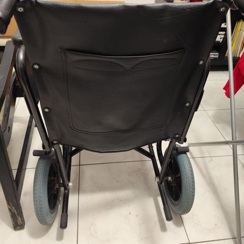 Manual wheelchair used with rear wheel brakes and belt