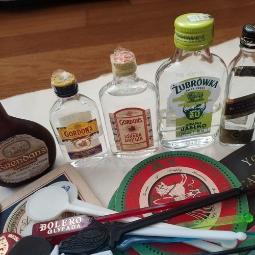 Vintage bar collection with mini liquor bottles, coasters, and stirrers