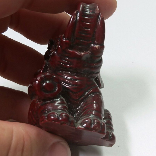 Carved miniature laughing elephant statue like new, burgundy color