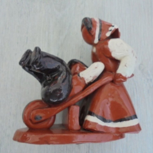Ceramic figure used, retro genre scene woman pushing man in cart