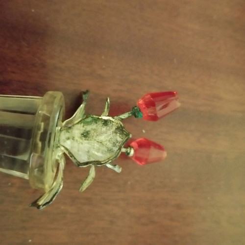 Glass bottle stopper used with decorative flowers and metal leaves