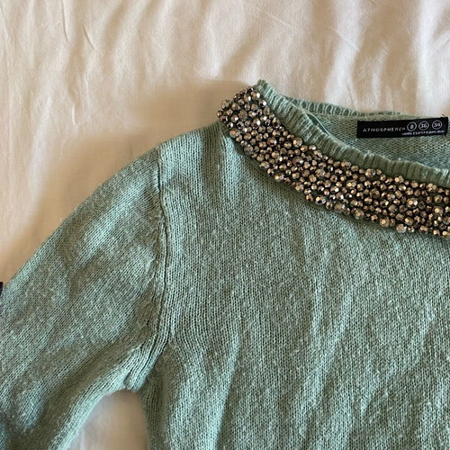 Thin turquoise sweater used with neckline details