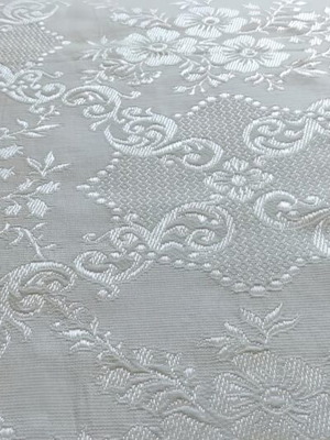 Woven quilt or throw with floral motifs, white