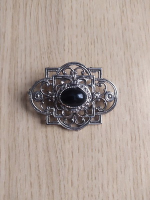 Metal brooch with black stone like new, silver color