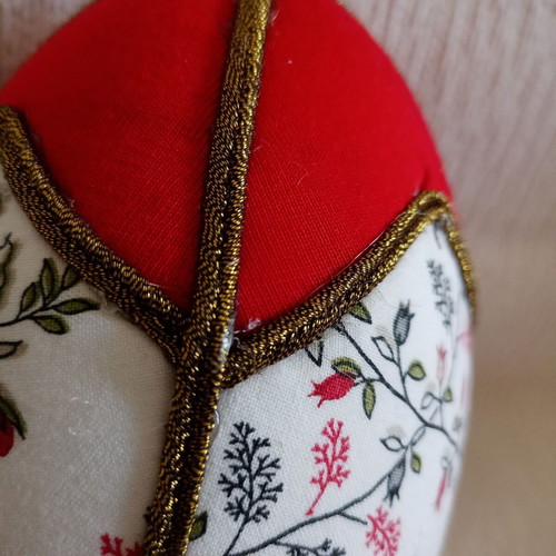 Decorative red egg used with geometric design and bronze border