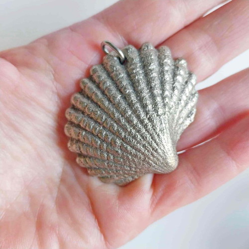 Metal shell pendant like new, silver color, solid metal