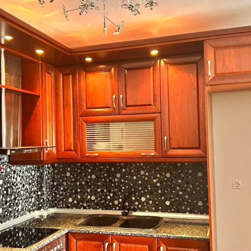 Corner kitchen made of solid cherry wood with extractor hood used