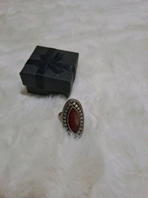 Ring used with large oval dark red stone in decorative bezel