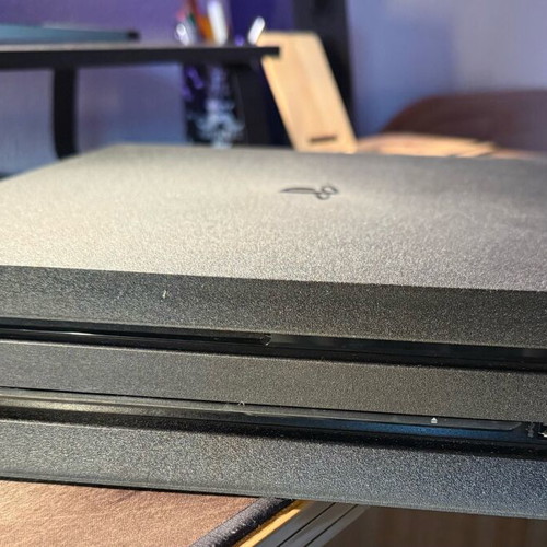 PlayStation 4 Pro used with controller and two games