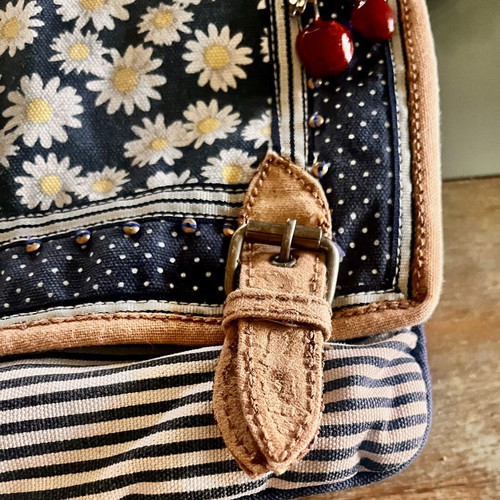 Accessorize vintage crossbody bag with daisies and cherries