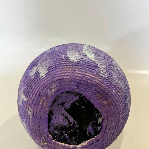 Vintage decorative glass vase covered with lilac rope, used