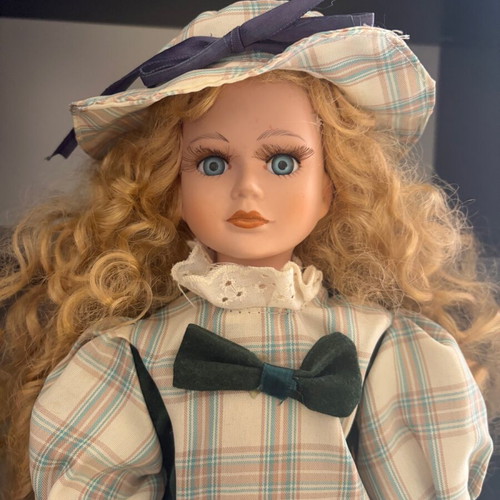 Porcelain doll like new with curly blonde hair and hat