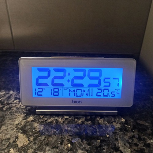 Digital table clock used with thermometer and alarm