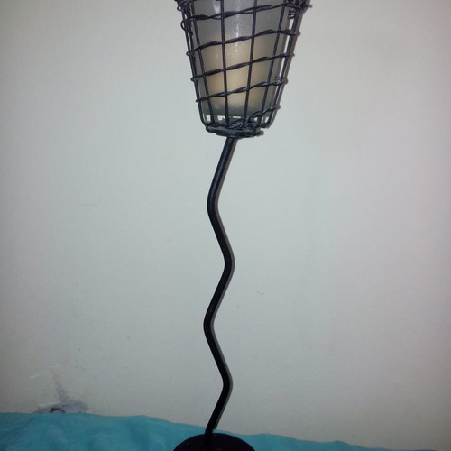 Metal candlestick used in modern design with glass cup