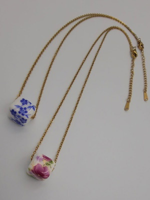Steel chain necklace with ceramic floral bead in blue and pink-red