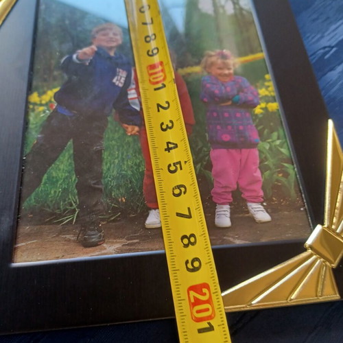 Black photo frame with golden decorative bows used