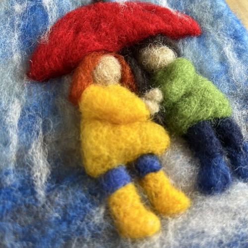 Handmade wool wall art with children under umbrella