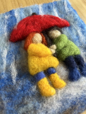 Handmade wool wall art with children under umbrella