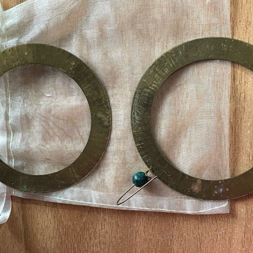 Handmade earrings used, round flat with green bead decoration