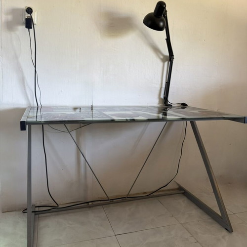 Desk with metal frame and glass surface featuring London images like new