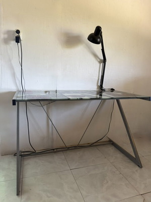 Desk with metal frame and glass surface featuring London images like new